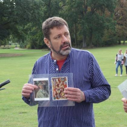 Carsten Ruthe erklärt einer Gruppe ein historisches Foto